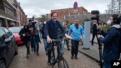Dutch caretaker Prime Minster Mark Rutte leaves on his bicycle after casting his vote in a general election in The Hague, March 17, 2021.