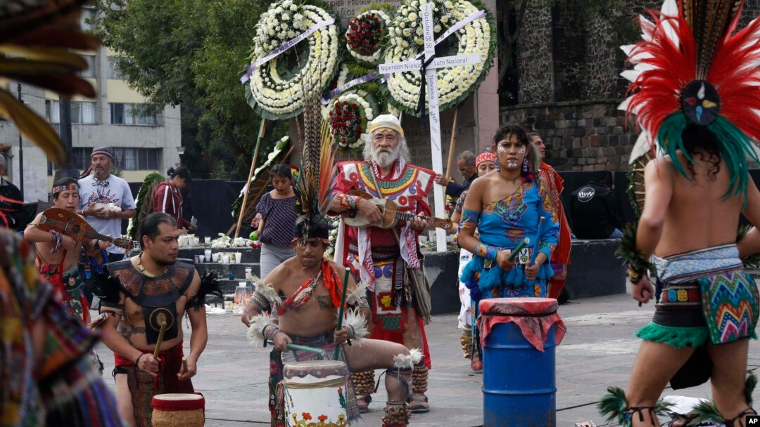 Aztec drummers and dancers perform in Tlatelolco plaza where wreaths have been laid in commemoration of the 1968 massacre of student protesters by army troops 50 years ago, in Mexico City, Tuesday, Oct. 2, 2018. Students and surviving leaders of the 1968 student democracy movement are planning marches Tuesday to mark the anniversary of an event that caused such revulsion it helped spur long-term political reforms.