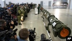 Foreign military attaches and journalists attend a briefing by the Russian Defense Ministry as the 9M729 land-based cruise missile, right, in Kubinka, Russia, Jan. 23, 2019. 