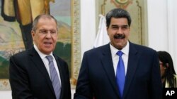 FILE - Venezuelan President Nicolas Maduro, right, shakes hands with Russia's Foreign Minister Sergey Lavrov during a photo opportunity at the end of their meeting at Miraflores presidential palace in Caracas, Venezuela, Feb. 7, 2020. 