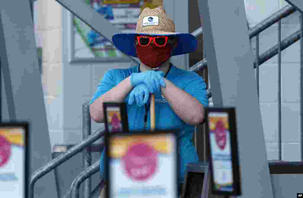 A worker stands ready to clean as waterparks reopened amid concerns of the spread of COVID-19, at the city-owned waterpark in Grand Prairie, Texas.