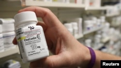 FILE - A pharmacist holds a bottle OxyContin made by Purdue Pharma at a pharmacy in Provo, Utah, May 9, 2019.