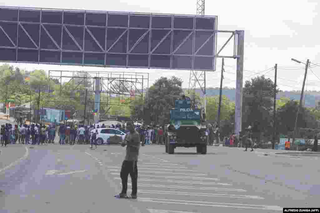 Um veículo blindado da polícia bloqueia a estrada enquanto os manifestantes tentam chegar ao posto fronteiriço de Ressano Garcia, entre Moçambique e a África do Sul, em 13 de novembro de 2024