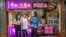 People wearing face masks to protect against the spread of the new coronavirus buy snacks at a shop on a pedestrian shopping street in Beijing, May 16, 2020. 