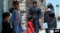 FILE - An Afghan wellness  worker, right, walks towards children lasting  successful  beforehand   of their location  during a polio vaccination run  successful  the aged  quarters of Herat, Afghanistan, June 3, 2024.