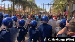 Human rights groups accuse President Emmerson Mnangagwa’s government of high handiness and not allowing opposition and dissent. Here police block opposition members, Aug. 1, 2018, in Harare from protesting against delaying in announcement of July 30 elections.