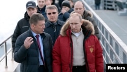 Russian President Vladimir Putin (R), Sberbank President German Gref (C) and Deputy Prime Minister Dmitry Kosak visit an Olympic venue near Sochi, Jan. 3, 2014.