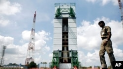 A paramilitary soldier walks past the Polar Satellite Launch Vehicle (PSLV-C25) at the Satish Dhawan Space Center at Sriharikota, in the southern Indian state of Andhra Pradesh, Oct. 30, 2013. 
