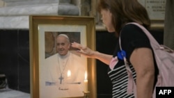 Un fiel toca un retrato del Papa Francisco durante una misa en la Basílica San José de Flores para orar por su salud en Buenos Aires el 19 de febrero de 2025.