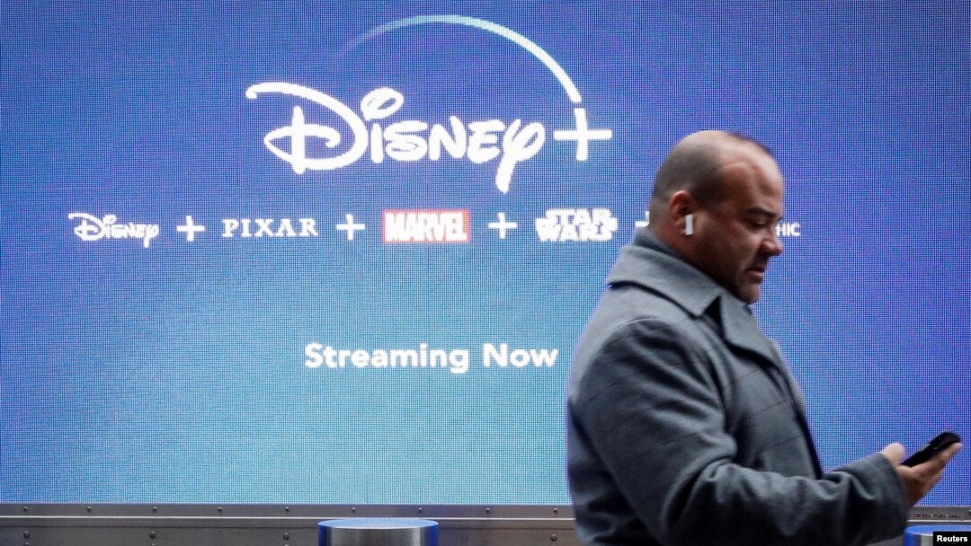 Un hombre mira su teléfono cuando pasa por una pantalla que anuncia el servicio de transmisión de Walt Disney Disney + en la ciudad de Nueva York, el 12 de noviembre de 2019.