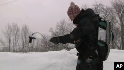 An image taken from video shows Patrick Alexander, a postdoctoral researcher at Columbia University's Lamont-Doherty Earth Observatory, using a spectrometer to measure light radiating off a snowpack in Highmount, N.Y., March 9, 2018.