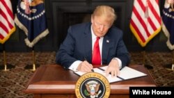 Le président Donald J. Trump signe une ordonnance sur les sanctions contre l'Iran, le 5 août 2018. 