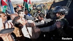 Palestinian minister Ziad Abu Ein (L) scuffles with an Israeli border policeman near the West Bank city of Ramallah, Dec. 10, 2014.