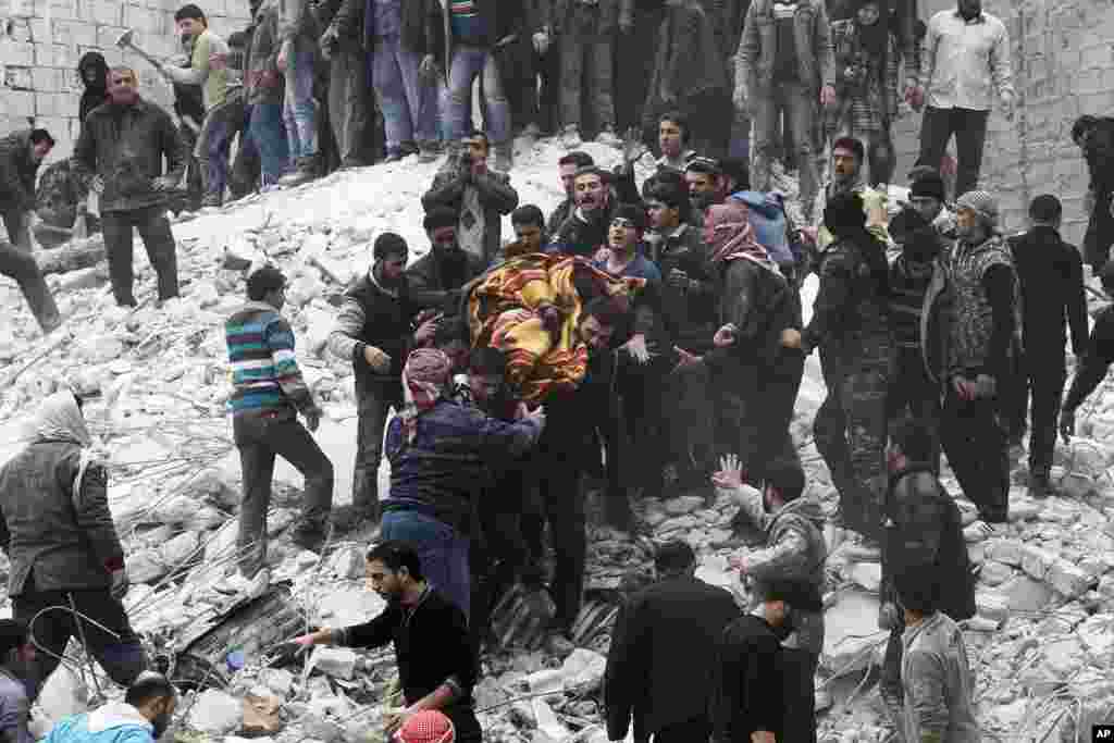 People carry a body after a government airstrike hit Ansari, Aleppo, Feb. 3, 2013. 