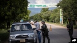 Policía inspecciona vehículos y a sus ocupantes en la entrada y salida de Barrancas, la ciudad colombiana en la que fue secuestrado el padre del futbolista Luis Díaz el pasado 28 de octubre por el ELN. Foto del 6 de noviembre.