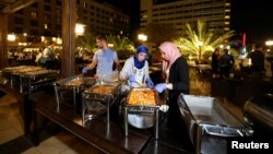 Para relawan inisiatif “Dapur Keluarga” mengemas makanan berlebih dari hotel-hotel bintang lima sebelum membagikan ke keluarga-keluarga kurang mampu di Amman, Yordania, 10 Juni 2018.
