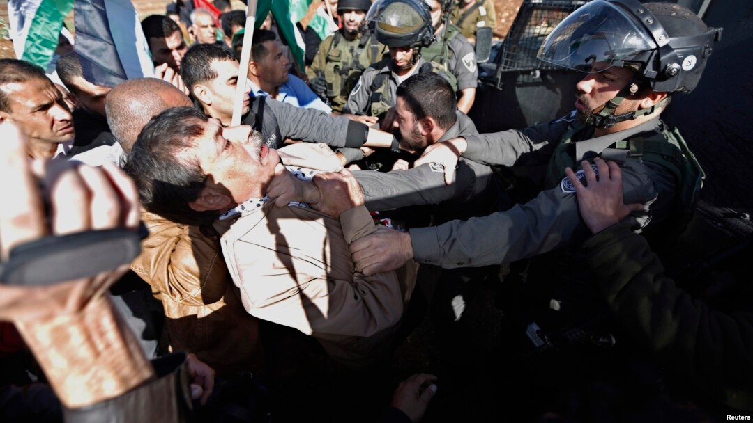 Menteri Palestina Ziad Abu Ein (kiri) saat bentrok dengan polisi Israel di dekat Ramallah, Tepi Barat Rabu (10/12).