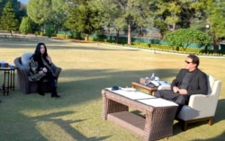 In this photo provided by Pakistan's Press Information Department, Cher, left, talks to Pakistan Prime Minister Imran Khan during their meeting in Islamabad, Nov. 27, 2020.