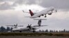 FILE - A Delta jet takes off in view of an Alaska Airlines plane that just landed at Seattle-Tacoma International Airport in Washington, Dec. 16, 2015. 