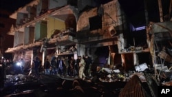 People gather in the aftermath of a multiple explosive attack in the Sayyida Zeinab area, 10 kilometers south of Damascus, Syria, Feb. 21, 2016. The Islamic State group claimed responsibility for a triple blast in the Shi'ite suburb. (AP Photo/Natalia Sancha) 