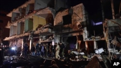 FILE - People gather in the aftermath of a multiple explosive attack in the Sayyida Zeinab area, 10 kilometers south of Damascus, Syria, Feb. 21, 2016. The Islamic State group claimed responsibility for a triple blast in the Shi'ite suburb.