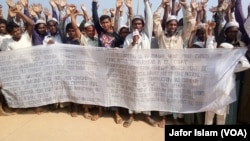 FILE - Some Rohingya refugees in Cox's Bazar, Bangladesh, are protesting against the community's repatriation to Myanmar, carrying a festoon on which their demands for repatriation are written.