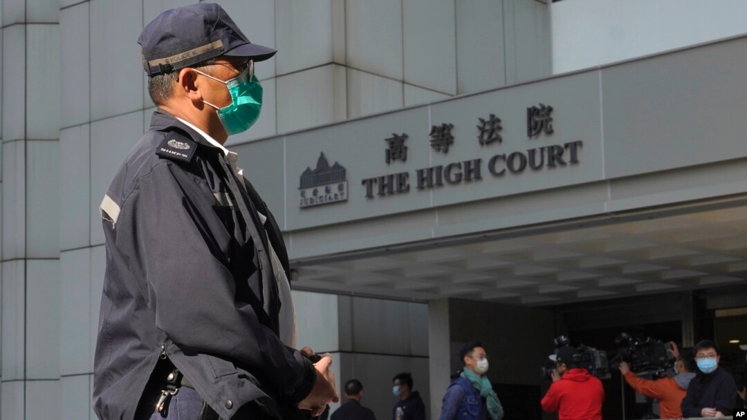 Seorang polisi berjaga di depan Pengadilan Tinggi Hong Kong, 18 Februari 2021. (AP Photo/Vincent Yu)