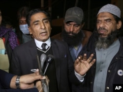 Lawyer Nadeem Ahmed Azar, L, and Sheikh Muhammad Aslam, brother of British-born Pakistani Ahmed Omar Saeed Sheikh, who is charged in the murder of American journalist Daniel Pearl, talks to media outside a prison in Karachi, Pakistan, Dec. 24, 2020.