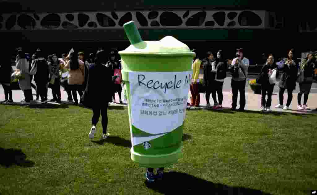 22일 한국 서울 시청역 앞에서 열린 지구의 날 행사에서, 한 시민이 일회용컵 복장을 하고 환경 캠페인에 참가했다. 