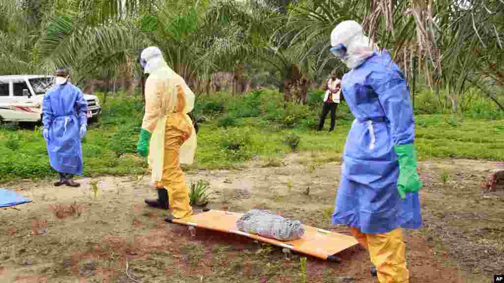 Des agents de la santé, vêtus d&rsquo;équipement de protection contre le virus Ebola, transportent sur une civière la dépouille d&#39;un enfant nouveau-né suspecté mort après avoir contracté l&rsquo;épidémie.