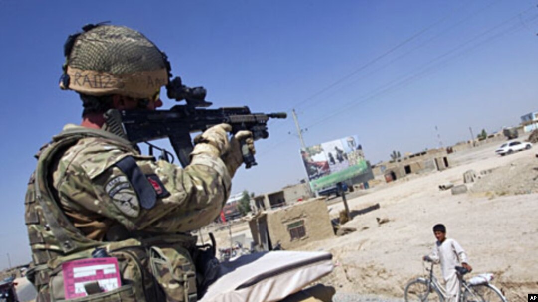A July 2011 file photo shows a British Army soldier looking through a sight of his rifle while driving on top of a Jackal armored vehicle in Lashkar Gah in Helmand province, southern Afghanistan