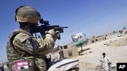 A July 2011 file photo shows a British Army soldier looking through a sight of his rifle while driving on top of a Jackal armored vehicle in Lashkar Gah in Helmand province, southern Afghanistan