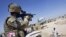 A July 2011 file photo shows a British Army soldier looking through a sight of his rifle while driving on top of a Jackal armored vehicle in Lashkar Gah in Helmand province, southern Afghanistan