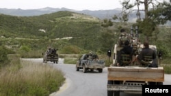 Rebel fighters drive in a convoy as they head toward what they said was an offensive to take control of Jisr al-Shughur and the surrounding areas, which are controlled by forces loyal to President Bashar al-Assad, April 20, 2015.