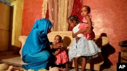 Youssria Awad juega con sus hijas en su casa, en Jartum, Sudán. Junio 14, 2020.