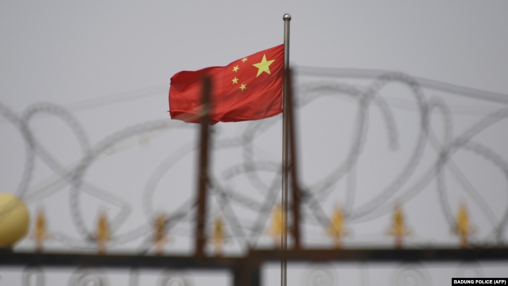 资料照：中国新疆喀什南部一处住宅区墙上的铁丝网与中国国旗。（2019年6月4日）(photo:VOA)