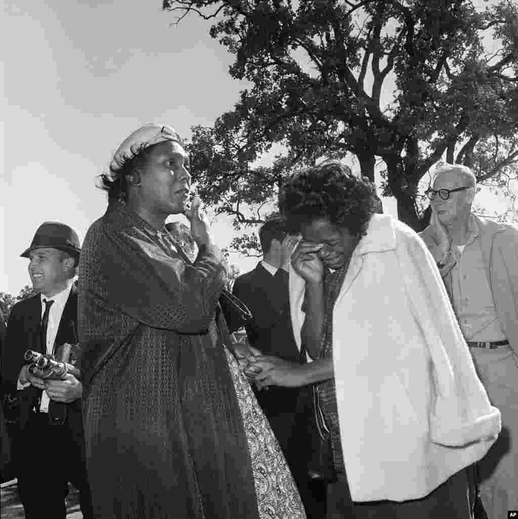 Two unidentified women burst into tears outside Parkland Hospital on hearing that President John F. Kennedy died from the bullet fired by an assassin while riding in a motorcade in Dallas, Nov. 22, 1963.