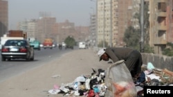 FILE - A man picks through rubbish on a road in Cairo, Egypt, Oct. 29, 2018.