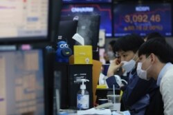 Currency traders watch monitors at the foreign exchange dealing room of the KEB Hana Bank headquarters in Seoul, South Korea, Jan. 8, 2021.