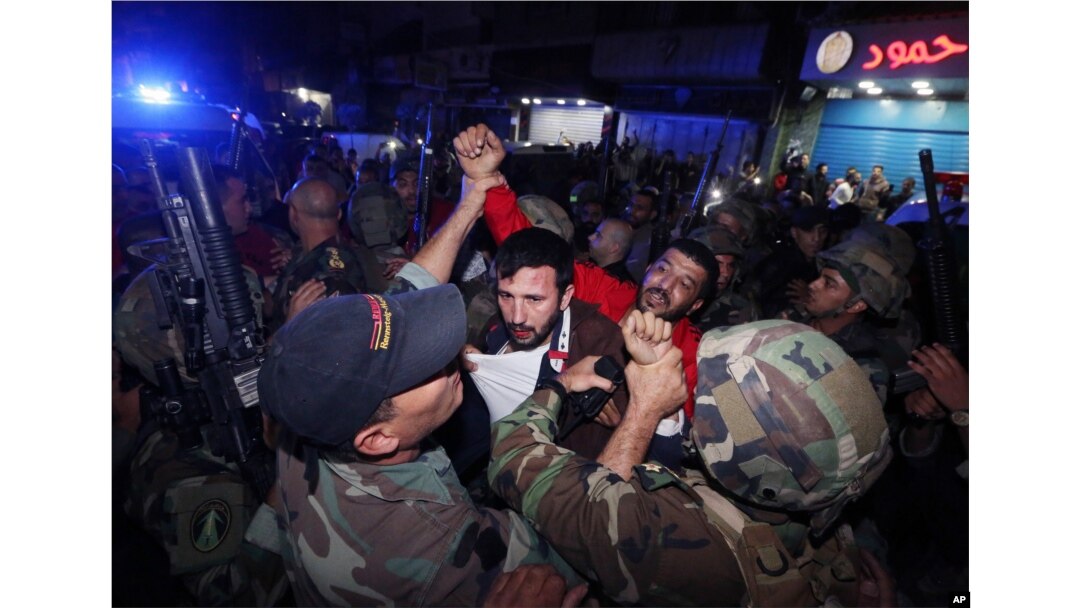 Lebanese soldiers arrest a suspected attacker near the scene of a twin suicide attack in Burj al-Barajneh, a predominantly Shi'ite suburb of southern Beirut, Lebanon, Nov. 12, 2015.