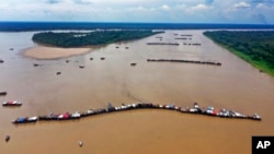 Dredging barges operated by illegal miners converge on the Madeira river, a tributary of the Amazon, searching for gold, in Autazes, Amazonas state, Brazil, Nov. 25, 2021.