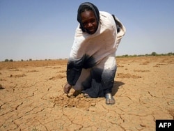 Cette photo d'Oxfam montre une femme sur une terre aride, à Oud Guedara, en Mauritanie (14 déc. 2011)