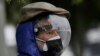 Un hombre vestido con un protector facial completo y una máscara doble para evitar el contagio del COVID-19 espera su turno para ser vacunado, afuera de un centro de vacunación del Instituto del Seguro Social en Quito, Ecuador, el jueves 6 de mayo de 2021. 