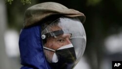 Un hombre vestido con un protector facial completo y una máscara doble para evitar el contagio del COVID-19 espera su turno para ser vacunado, afuera de un centro de vacunación del Instituto del Seguro Social en Quito, Ecuador, el jueves 6 de mayo de 2021. 