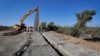 Government contractors erect a section of border wall along the Colorado River, Sept. 10, 2019 in Yuma, Ariz. Construction began as federal officials revealed a list of Defense Department projects to be cut to pay for the wall.