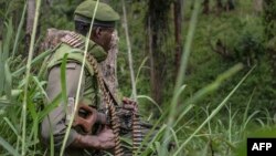 Un soldat des FARDC (Forces Armées de la République démocratique du Congo) prend position lors d'échanges de tirs avec des membres de l'ADF (Forces Démocratiques Alliées) à Opira, Nord Kivu, 25 janvier 2018.