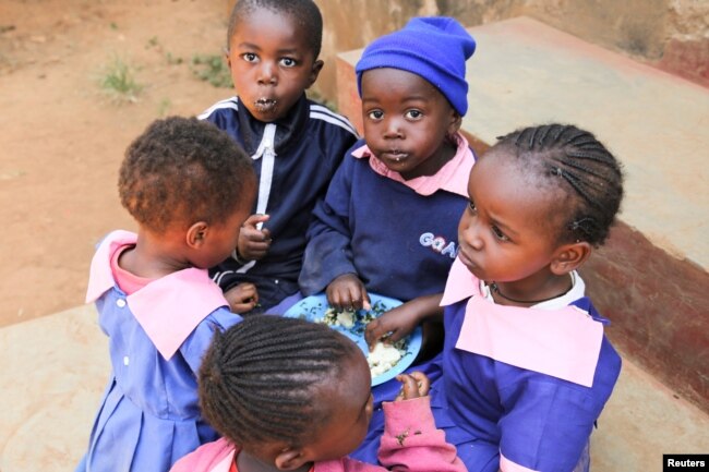 Girls and boys share a meal at the Makini Self-Help Primary School in Kibera, Nairobi, Kenya, Sept. 23, 2016.