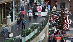 FILE- In this Dec. 22, 2017, file photo people shop at the Pentagon City Mall in Arlington, Va.