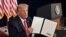 El presidente Donald Trump muestra a las cámaras una de las órdenes ejecutivas para asistencia federal por el coronavirus firmadas el sábado 8 de agosto de 2020.