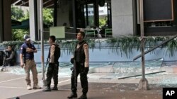 Polisi berjaga di sekitar gerai Starbucks di Jakarta yang hancur pasca serangan hari Kamis, 14 Januari 2016. (Foto: AP/Achmad Ibrahim)